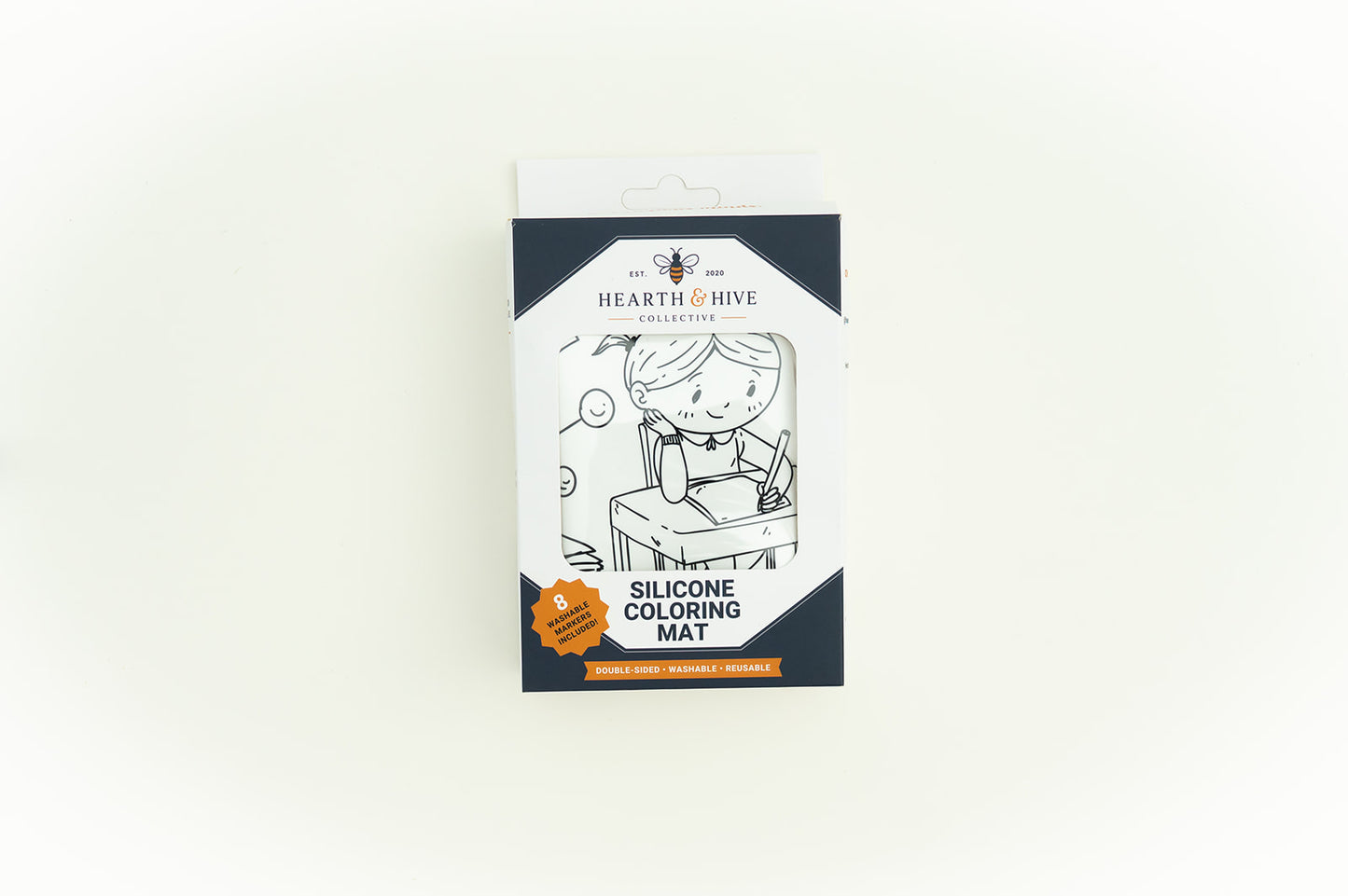 Hearth & Hive Silicone Coloring Mat in its original packaging, featuring a black and white illustration of a child coloring on a desk, set against a plain white background.
